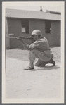 Man in uniform kneeling with rifle
