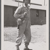 Man in uniform standing with rifle over shoulder