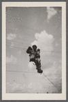 Man in uniform climbing barb wire