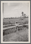 Man in uniform standing by barb wire