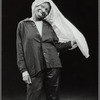 Publicity photograph of Whoopi Goldberg performing stand-up act  in leather pants, wearing a shirt on her head
