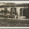 Two women in front of a cottage with a dog