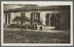 Two women in front of a cottage with a dog