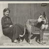 Woman seated in a doorway with a dog