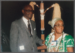 Mestre Didi standing with guest at the reception for his 1986 exhibition "Mestre Didi: An Afro-Brazilian Artist"