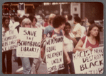 Group marching with signs at "Save the Schomburg" Rally 