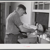 E. O. Foster's son (tenant purchase family) washing milk bottles in their Caswell dairy. Caswell County, North Carolina.