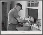 E. O. Foster's son (tenant purchase family) washing milk bottles in their Caswell dairy. Caswell County, North Carolina.