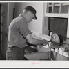 E. O. Foster's son (tenant purchase family) washing milk bottles in their Caswell dairy. Caswell County, North Carolina.