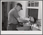 E. O. Foster's son (tenant purchase family) washing milk bottles in their Caswell dairy. Caswell County, North Carolina.