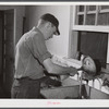 E. O. Foster's son (tenant purchase family) washing milk bottles in their Caswell dairy. Caswell County, North Carolina.