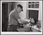 E. O. Foster's son (tenant purchase family) washing milk bottles in their Caswell dairy. Caswell County, North Carolina.
