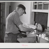 E. O. Foster's son (tenant purchase family) washing milk bottles in their Caswell dairy. Caswell County, North Carolina.