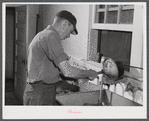 E. O. Foster's son (tenant purchase family) washing milk bottles in their Caswell dairy. Caswell County, North Carolina.