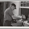 E. O. Foster's son (tenant purchase family) washing milk bottles in their Caswell dairy. Caswell County, North Carolina.