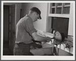 E. O. Foster's son (tenant purchase family) washing milk bottles in their Caswell dairy. Caswell County, North Carolina.