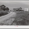 Tobacco barns and cigarette advertisements on country road in Prospect Hill section. Caswell County, North Carolina.