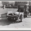 Farmer returning home after selling his tobacco at auction. In the trailer are sacks of flour and meal and the tobacco sticks. Yanceyville, Caswell County, North Carolina.