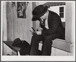 Fur buyer figuring out his bid on the next lot of muskrat pelts. The auction sale is held in a dance hall on Delacroix Island, Saint Bernard Parish, Louisiana.