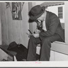 Fur buyer figuring out his bid on the next lot of muskrat pelts. The auction sale is held in a dance hall on Delacroix Island, Saint Bernard Parish, Louisiana.