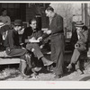Fur buyer handing FSA (Farm Security Administration) supervisor his bid on the next lot of muskrats. The auction sale is being held on the porch of the community general store in Saint Bernard, Louisiana.