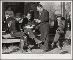 Fur buyer handing FSA (Farm Security Administration) supervisor his bid on the next lot of muskrats. The auction sale is being held on the porch of the community general store in Saint Bernard, Louisiana.