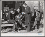 Fur buyer handing FSA (Farm Security Administration) supervisor his bid on the next lot of muskrats. The auction sale is being held on the porch of the community general store in Saint Bernard, Louisiana.