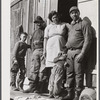 Spanish muskrat trapper with his father, his wife and their two children, in front of their camp in the marshland. Delacroix Island, Saint Bernard Parish, Louisiana.