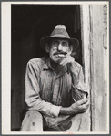 Spanish muskrat trapper in doorway of his marsh camp. Delacroix Island, Saint Bernard Parish, Louisiana