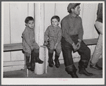 Fur trappers and his two children waiting for the bids on the next lot of muskrats to come in. The auction sale is being held in a dance hall on Delacroix Island, Saint Bernard Parish, Louisiana.