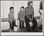 Fur trappers and his two children waiting for the bids on the next lot of muskrats to come in. The auction sale is being held in a dance hall on Delacroix Island, Saint Bernard Parish, Louisiana.