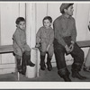 Fur trappers and his two children waiting for the bids on the next lot of muskrats to come in. The auction sale is being held in a dance hall on Delacroix Island, Saint Bernard Parish, Louisiana.