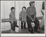 Fur trappers and his two children waiting for the bids on the next lot of muskrats to come in. The auction sale is being held in a dance hall on Delacroix Island, Saint Bernard Parish, Louisiana.