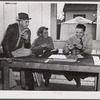 FSA (Farm Security Administration) Supervisor examining one of the trapper's furs during an auction sale held in a dance hall on Delacroix Island, Saint Bernard Parish, Louisiana.