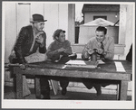FSA (Farm Security Administration) Supervisor examining one of the trapper's furs during an auction sale held in a dance hall on Delacroix Island, Saint Bernard Parish, Louisiana.