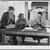FSA (Farm Security Administration) Supervisor examining one of the trapper's furs during an auction sale held in a dance hall on Delacroix Island, Saint Bernard Parish, Louisiana.