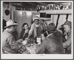 Spanish muskrat trappers drinking wine and playing "cache," a form of poker, in their camp in the marshes. Delacroix Island, Saint Bernard Parish, Louisiana.