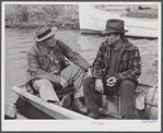 FSA (Farm Security Administration) supervisor talking to one of the trappers in his boat by one of the bayou marsh camps. Delacroix Island, Saint Bernard Parish, Louisiana.