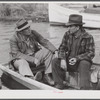 FSA (Farm Security Administration) supervisor talking to one of the trappers in his boat by one of the bayou marsh camps. Delacroix Island, Saint Bernard Parish, Louisiana.