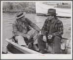 FSA (Farm Security Administration) supervisor talking to one of the trappers in his boat by one of the bayou marsh camps. Delacroix Island, Saint Bernard Parish, Louisiana.