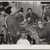 Spanish muskrat trappers drinking wine and playing "cache," a form of poker, in their camp in the marshes. Delacroix Island, Saint Bernard Parish, Louisiana.