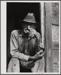 Spanish muskrat trapper in doorway of his marsh camp. Delacroix Island, Saint Bernard Parish, Louisiana.