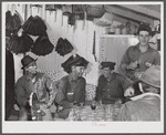 Spanish muskrat trappers drinking wine after dinner. On the walls of their marsh camp are hung the dried pelts. Delacroix Island, Saint Bernard Parish, Louisiana.