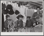 Spanish muskrat trappers drinking wine after dinner. On the walls of their marsh camp are hung the dried pelts. Delacroix Island, Saint Bernard Parish, Louisiana.