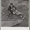 Spanish trapper's son setting the trap which he made to catch birds by his camp in the marshes near Delacroix Island, Louisiana.