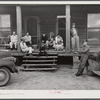 Construction workers on porch of local boarding house on highway near Fort Benning, Columbus, Georgia. They pay six dollars a week, several in a room. They are employed on Belair Construction job building defense housing project.