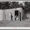 Construction workers from Monroe, Louisiana, washing in front of their shack. Water must be hauled from a nearby church faucet. They are living on government property (no rent) while working at Camp Livingston near Fort Beauregard, Alexandria, Louisiana.