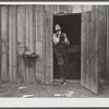 Charles B. Griggs shaving in front of his self-built shack on government property . He used to work on his farm outside Monroe, LA, but came to work on construction job at Camp Livingston near Fort Beauregard because he could make more money.