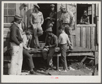 Migratory laborers playing checkers in front of juke joint during slack season for vegetable pickers. Belle Glade, Florida.