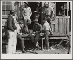 Migratory laborers playing checkers in front of juke joint during slack season for vegetable pickers. Belle Glade, Florida.